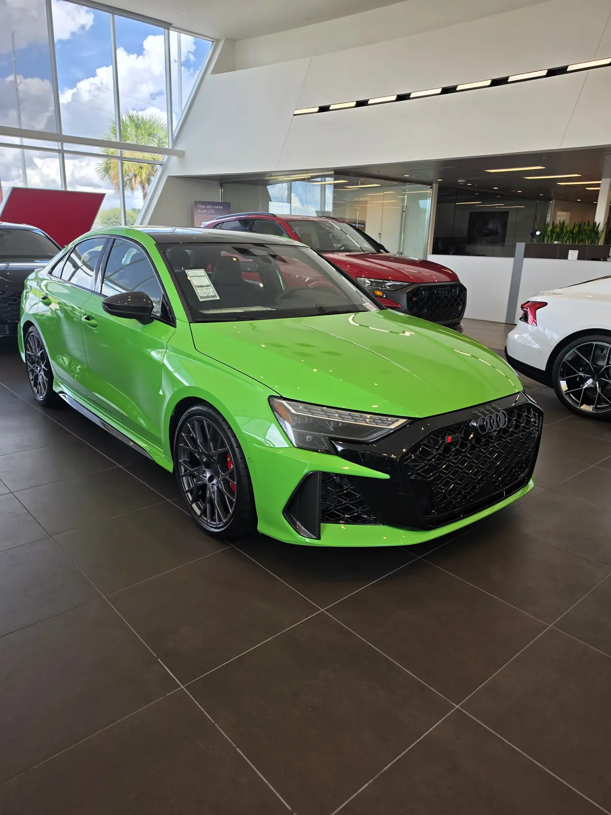 Green performance SUV photographed in a showroom