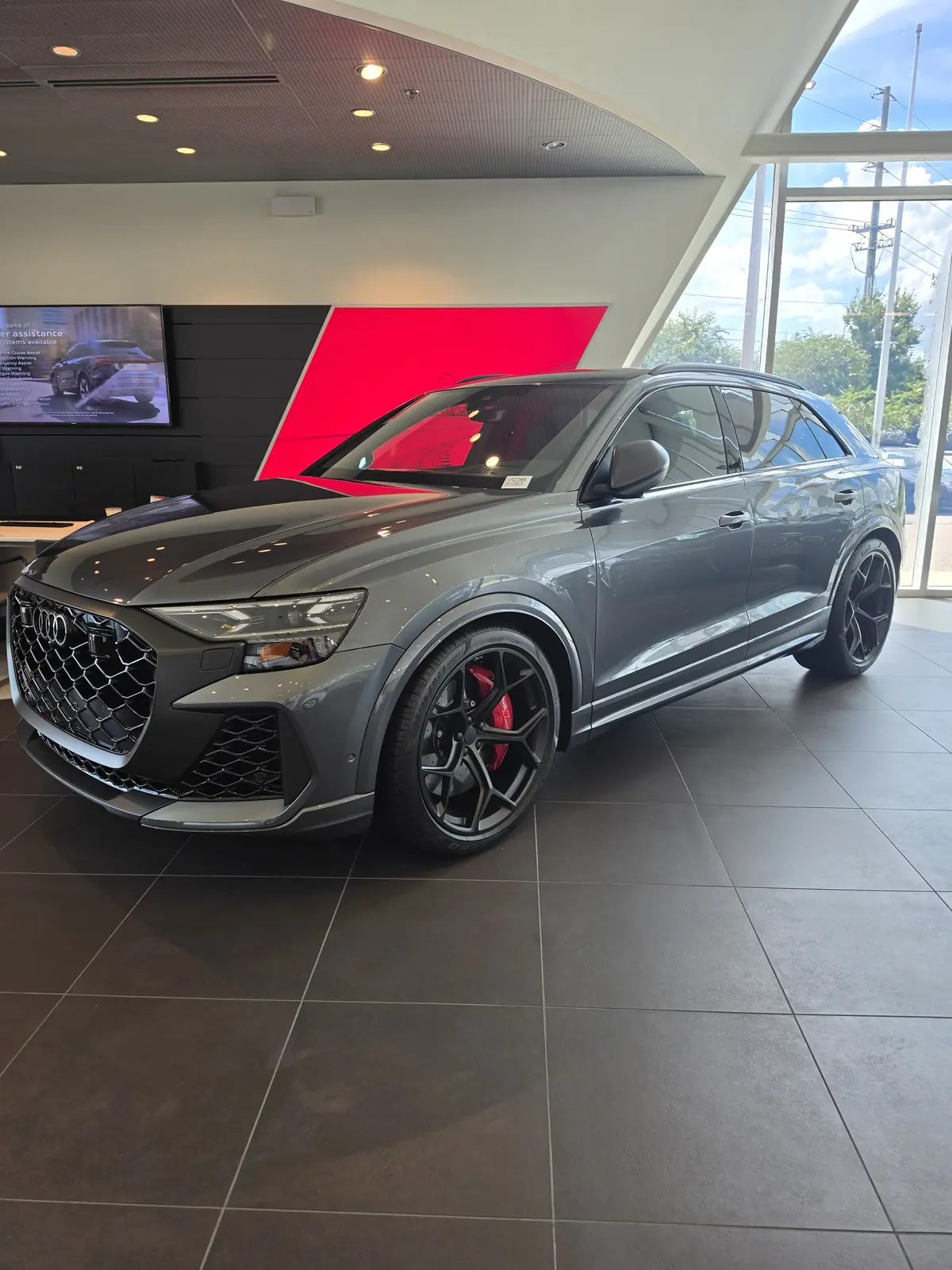 Gray SUV with red brake calipers in a showroom