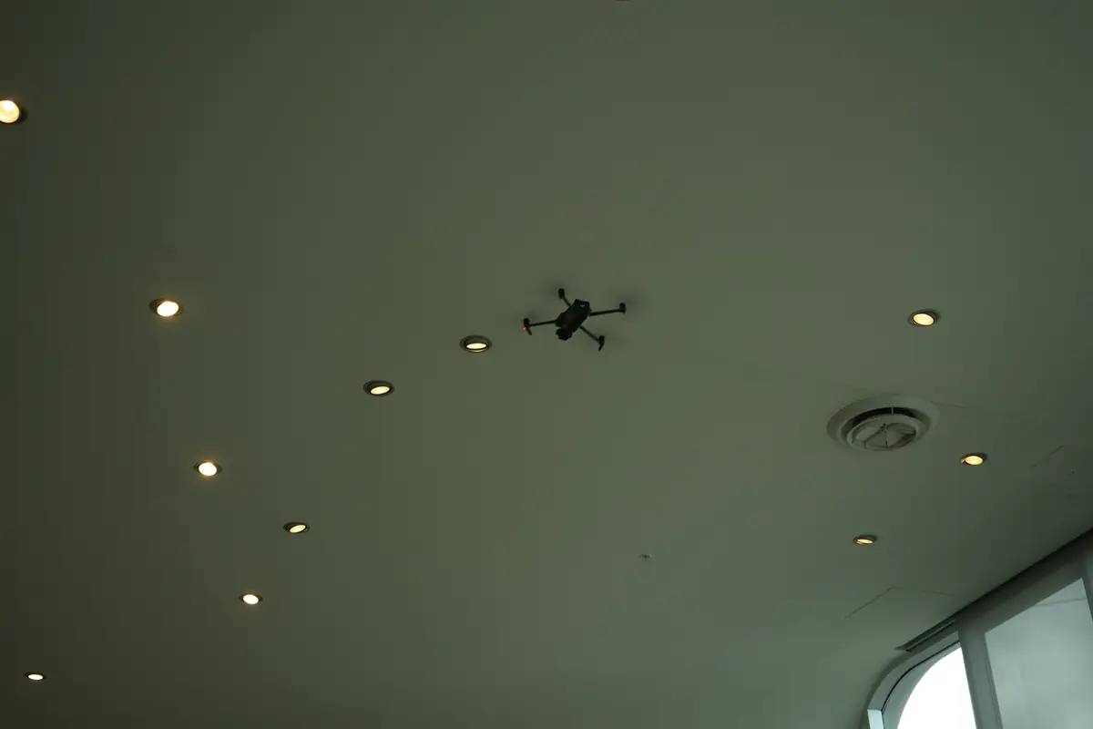 Drone hovering under a showroom ceiling during a video shoot
