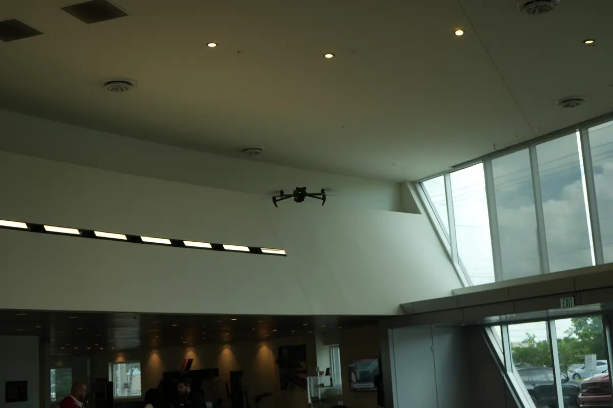Drone flying inside a dealership showroom with large windows