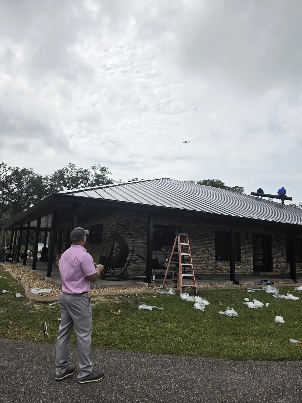Drone roof inspection in progress beside a house